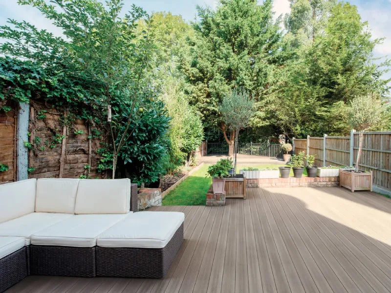 Fiberon Good Life composite decking in a serene backyard with lush greenery and outdoor seating.