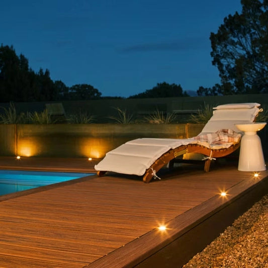 Poolside deck in Trex Transcend Tiki Torch with fascia and step lights at dusk