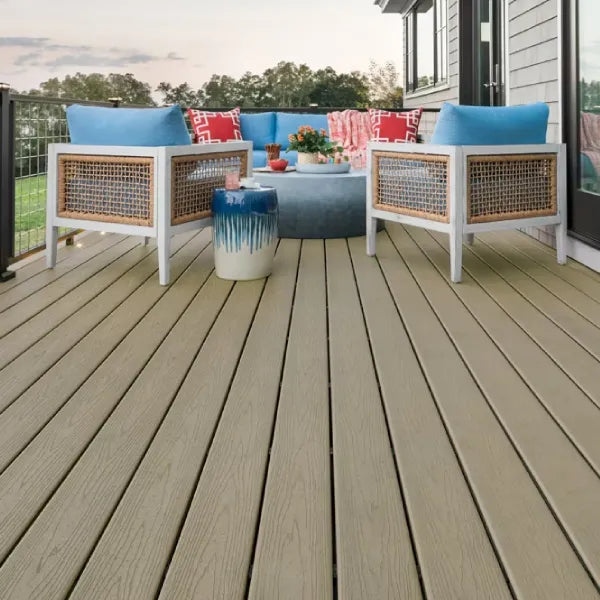 Outdoor seating area on Trex Transcend decking in Rope Swing color, featuring wicker chairs and vibrant pillows.