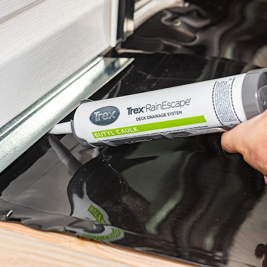 Applying Trex RainEscape butyl caulk along a deck drainage membrane