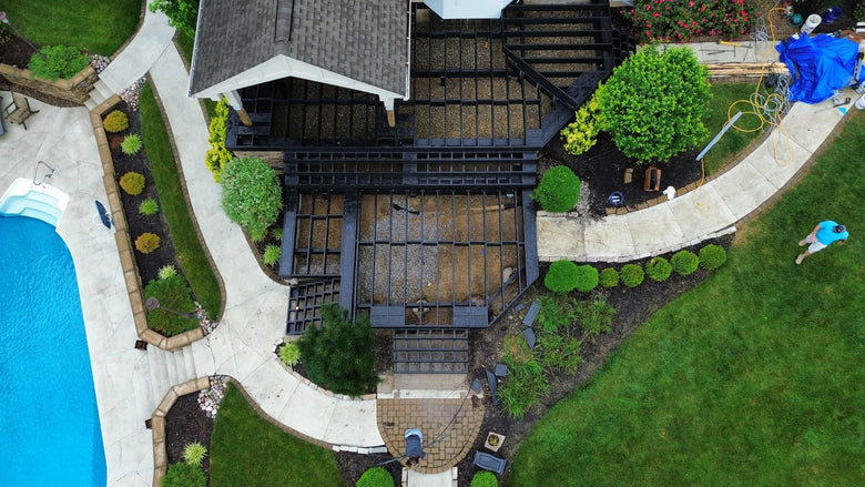 Aerial view of a backyard with a pool, patio, and landscaping