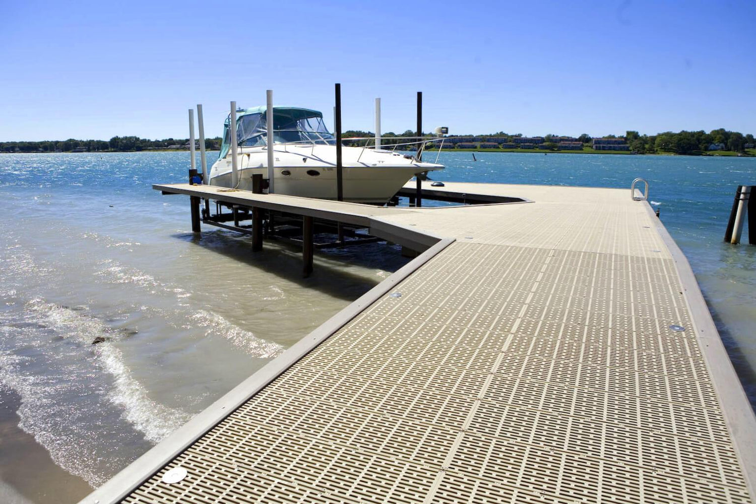 Boat docked at a wooden pier with water and clear sky in the background