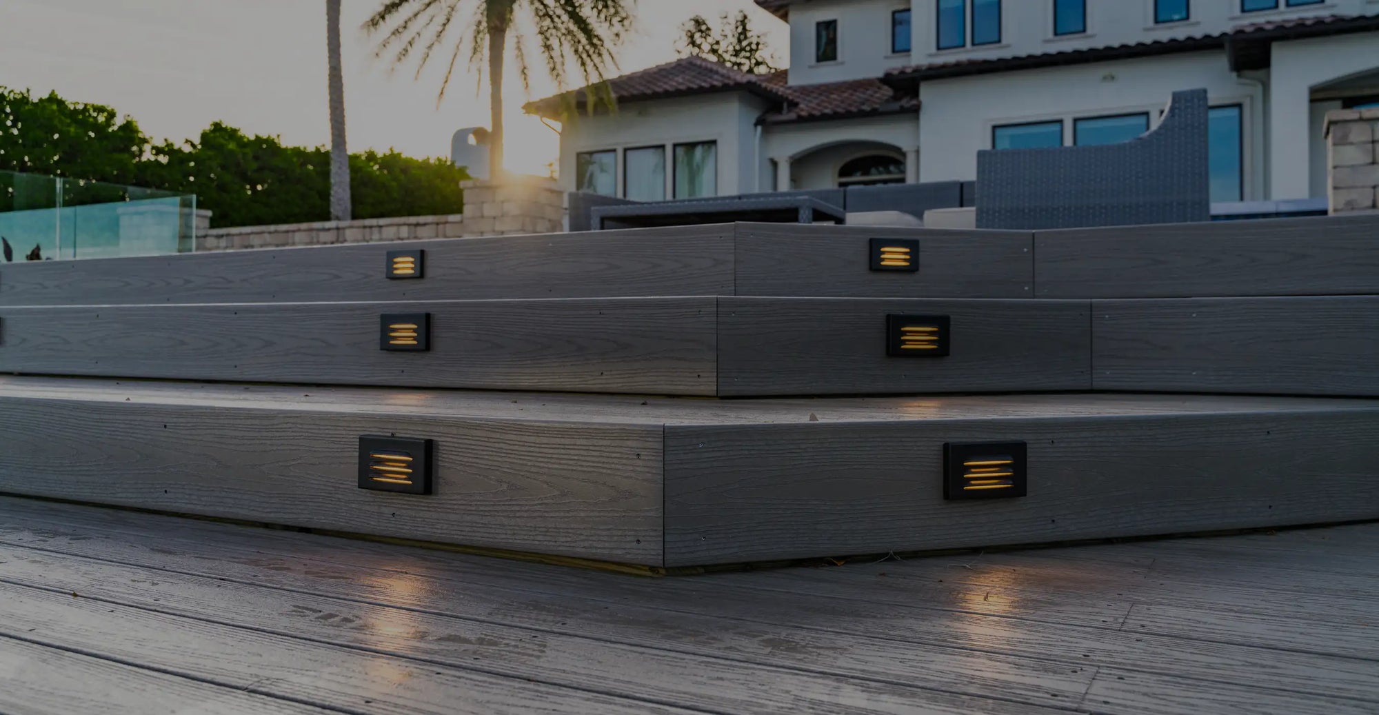 Outdoor decking setup at a luxury home, featuring gray steps with built-in deck lighting. 