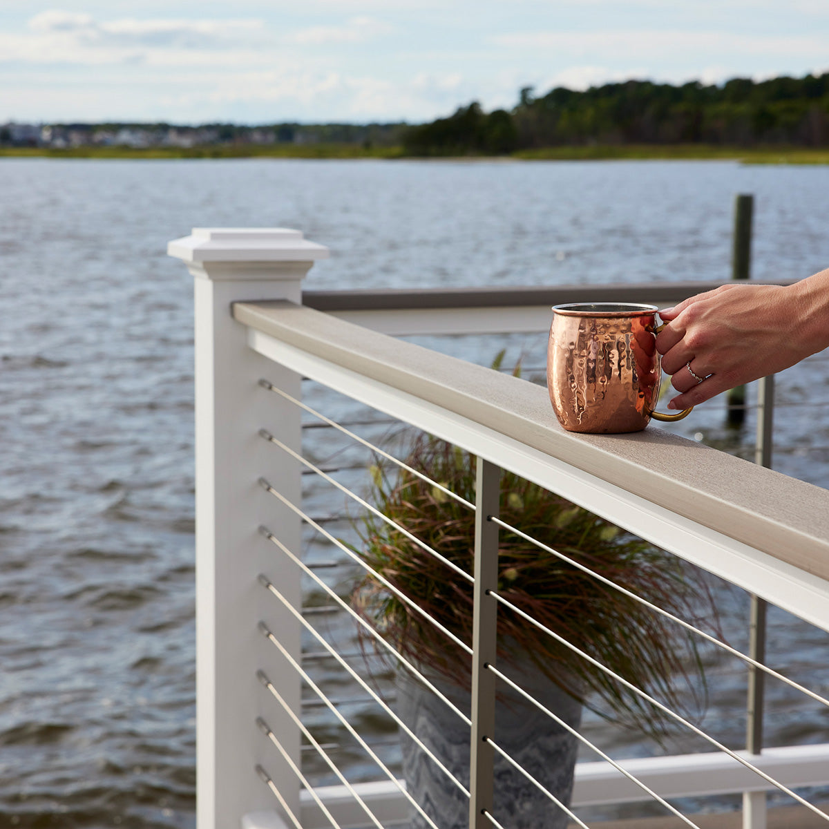 holding a cup of drink on the Rail on the deck