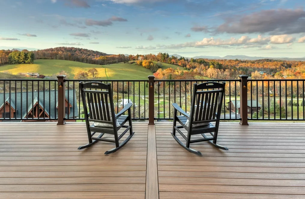 Two rocking chairs on a Trex deck with Signature railing, overlooking a scenic view of rolling hills and autumn foliage