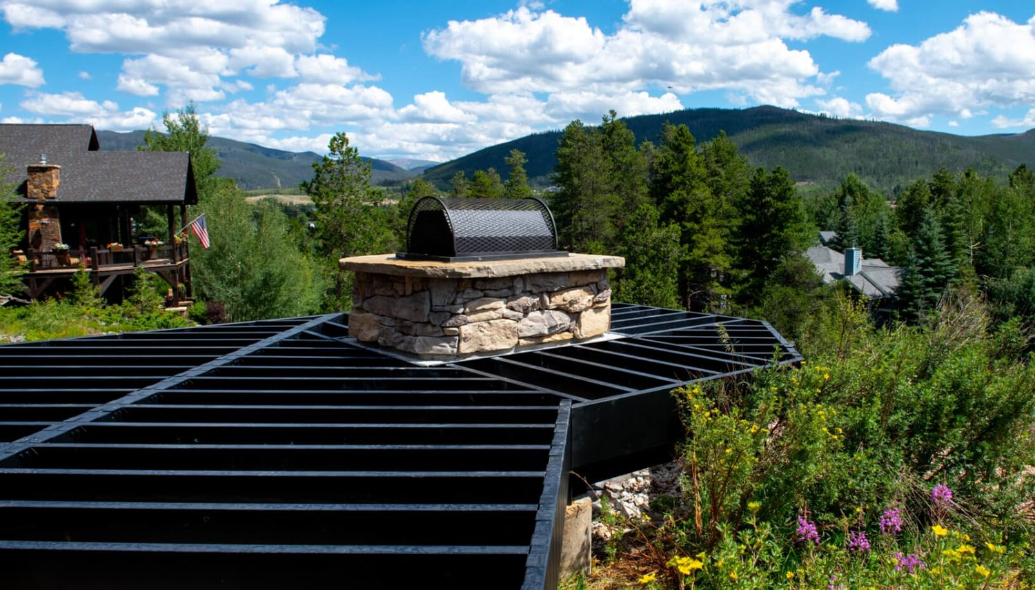 Outdoor stone barbecue grill on a deck with scenic mountain view