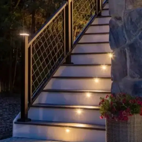 Staircase with Trex riser lights and sleek black railing, adding warmth and style to the outdoor area.